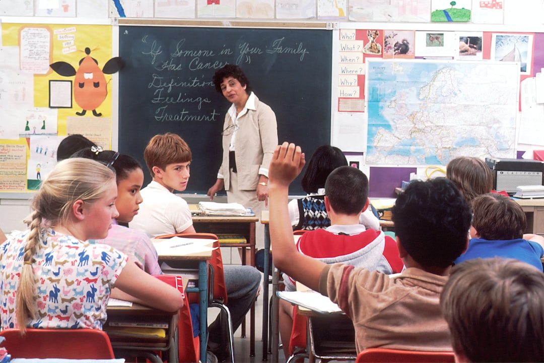 Children in a Classroom. In the back of a classroom, are children about 11 years old with a female teacher talking about the subject - If Someone in Your Family Has Cancer. Photographer Michael Anderson by Hispanic Month woman standing in front of children