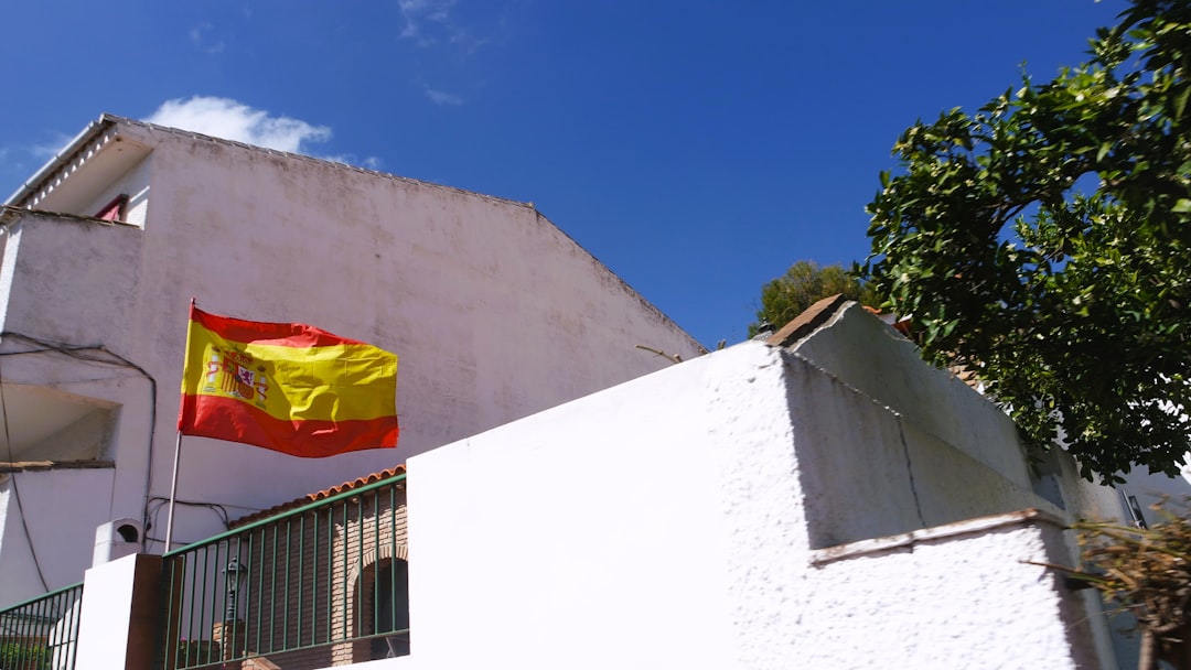 Spotlight on Excellence: Iconic Hispanic and Latinx Figures Who Shaped History by Hispanic Month a yellow and red flag on a white building