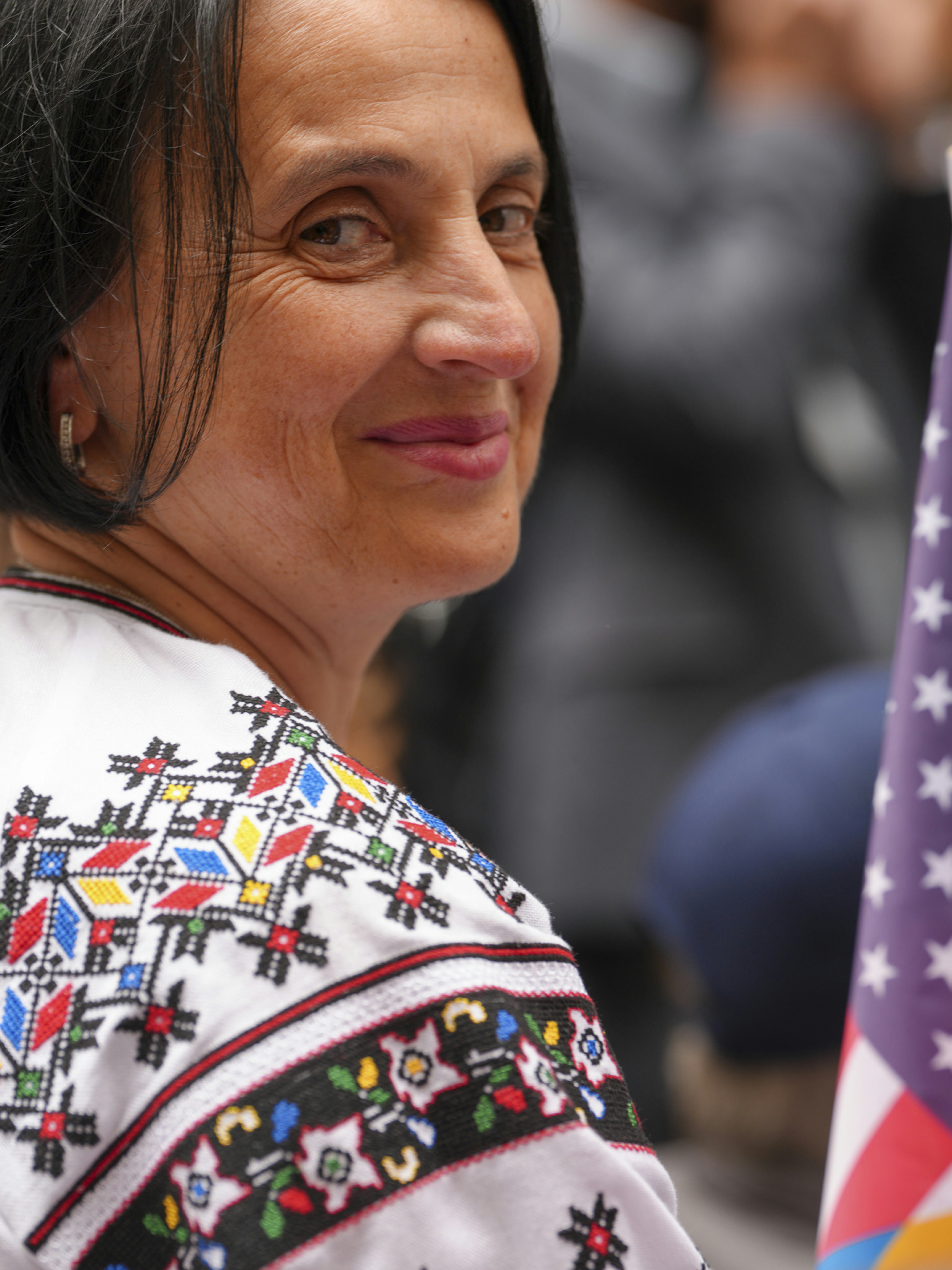 Woman in traditional embroidered shirt smiles